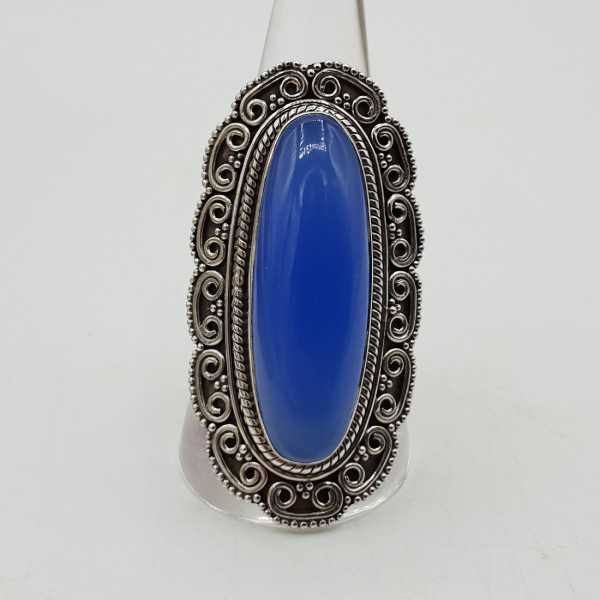 A silver ring with a blue Chalcedony, and carved heads