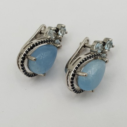 Silver earrings with aquamarine blue topaz and black spinning